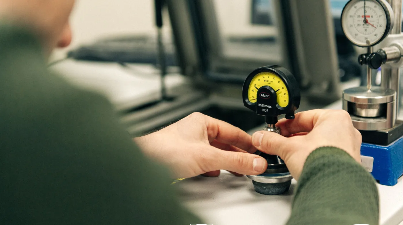 Un technicien étalonne un instrument de mesure avec un comparateur Mahr Millimess gradué au micron